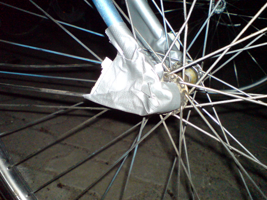 Mécanicien ajustant le dérailleur d'un vélo sur un pied d'atelier chez ApartDaily